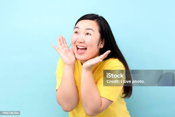 Portrait Asia Woman Yelling And Hand On His Mouth Isolated On Blue 