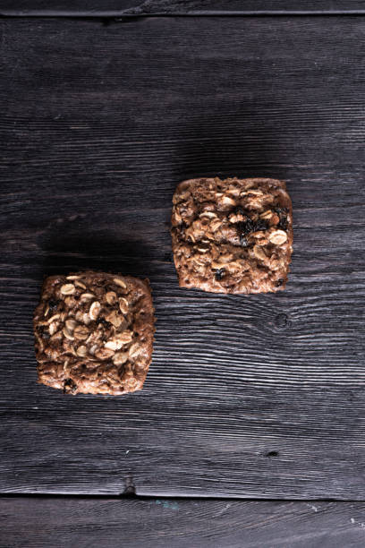 farina d'avena e muffin al cioccolato giacciono su un tavolo grigio legno in stile rustico. prescrizione di cibo sano - muffin blueberry muffin blueberry food foto e immagini stock