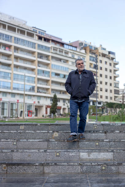 istock Senior man with a beard walking in the city 1195738896