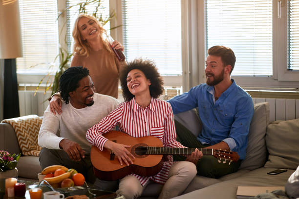 istock Cheerful friends enjoying with guitar 1195741532