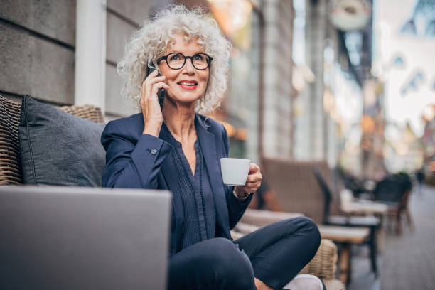 istock Woman talking on mobile outdoors in cafe 1195743538