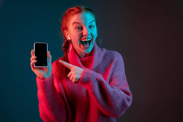 istock Caucasian woman's portrait isolated on gradient studio background in neon light 1195744933