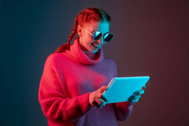 istock Caucasian woman's portrait isolated on gradient studio background in neon light 1195745487