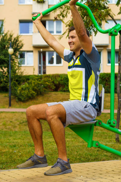 istock Man flexing arm in outdoor gym 1195746347
