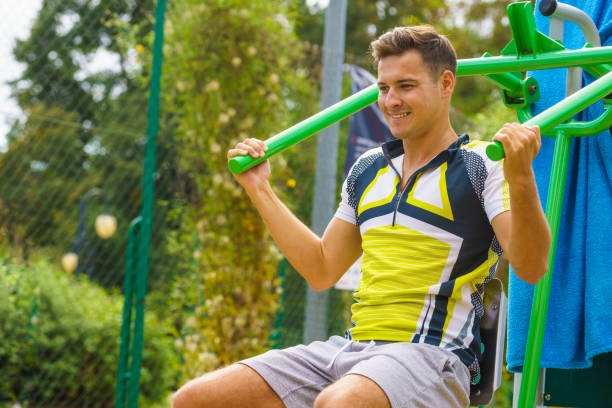 istock Man flexing arm in outdoor gym 1195747103