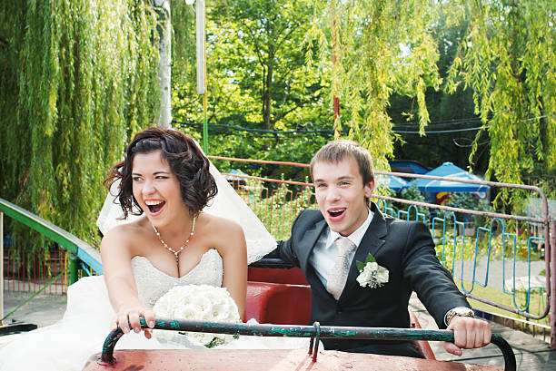 newlyweds on rollercoaster stock photo