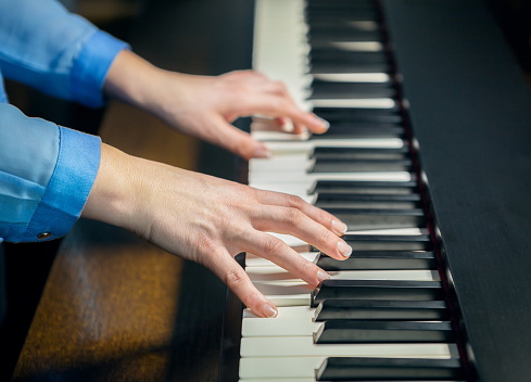 female hands playing the piano