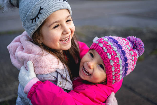 Cheerful children embracing each other in love in the city.
