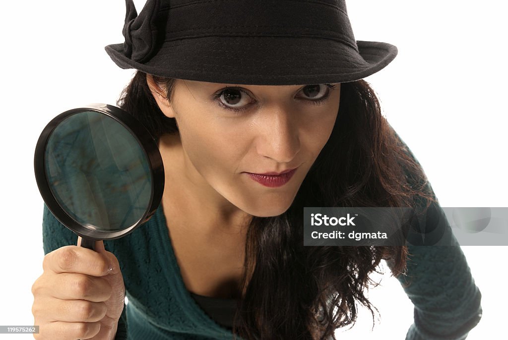 young woman with magnifier glass and hat looking to camera  Adult Stock Photo