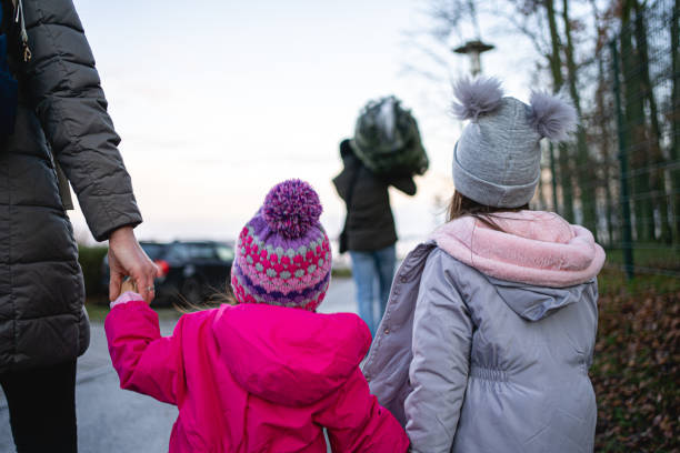 Father carrying a Christmas tree, while mother's holding hands of two dayghters in Stralsund, Mecklenburg-Vorpommern, going home to decorate a Christmas tree during a new year's eve.