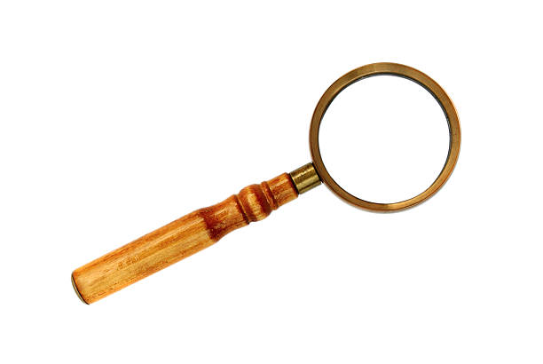 Top-down view of a magnifying glass on wooden desk