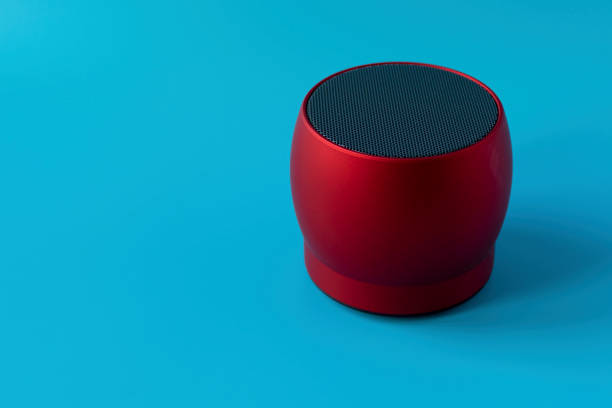 istock Wireless and powerful red bluetooth speaker on a blue background. Speaker to enhance volume. 1195754128