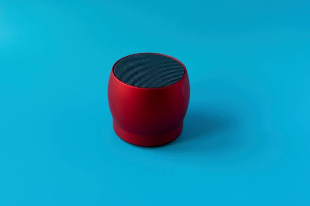 istock Wireless and powerful red bluetooth speaker on a blue background. Speaker to enhance volume. 1195755036