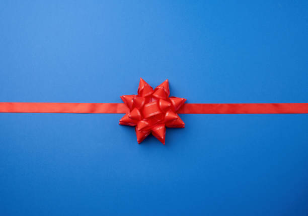 istock red silk ribbon and a large knotted bow on a blue background 1195755082