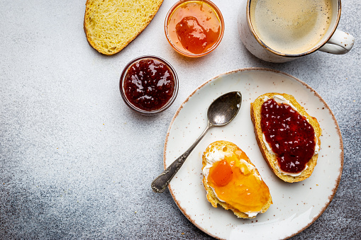 Sandwich with various sweet fruit jams and cottage cheese on light background, top view with copy space