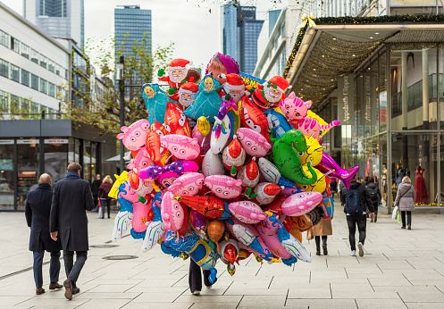 Frankfurt, Germany - Rear view of a balloon seller with a large collection of helium balloons featuring various characters, on a street in Frankfurt.