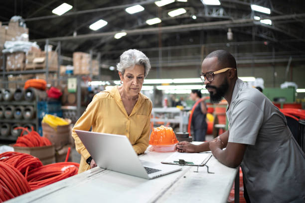 istock Coworkers using laptop in industry 1195758446