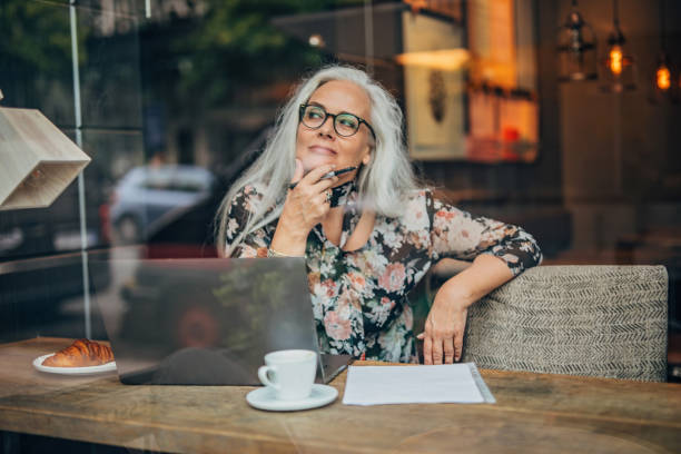 istock Old business lady sitting in cafe alone 1195759735