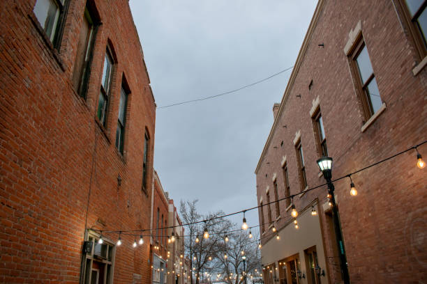 istock Lights strung between two old downtown buildings and an overcast sky 1195760508