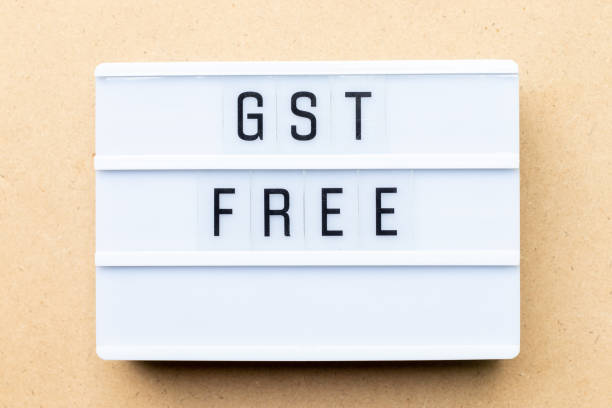 istock White lightbox with word GST (Abbreviation of Goods and Service Tax) free on wood background 1195762487