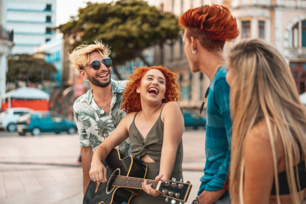 istock Young people singing and playing guitar outdoors 1195765481