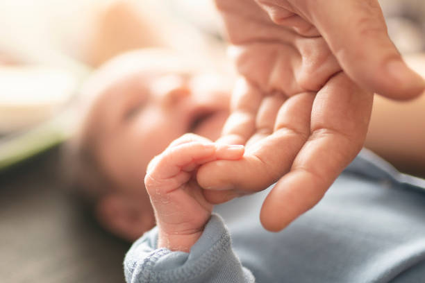 istock Baby Holding Mothers Hand 1195767755