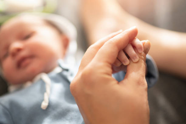 istock Baby Holding Mothers Hand 1195767756