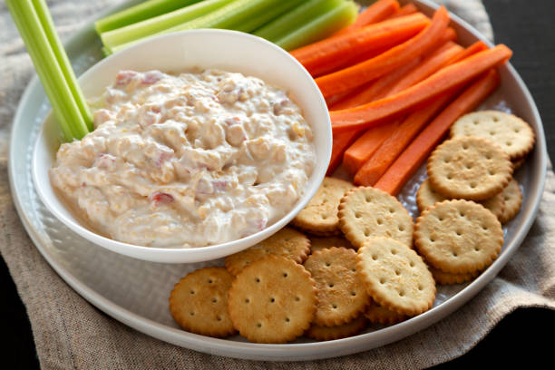 istock Homemade Southern Pimento Cheese with carrots, celery and crackers, low angle view. Close-up. 1195771699