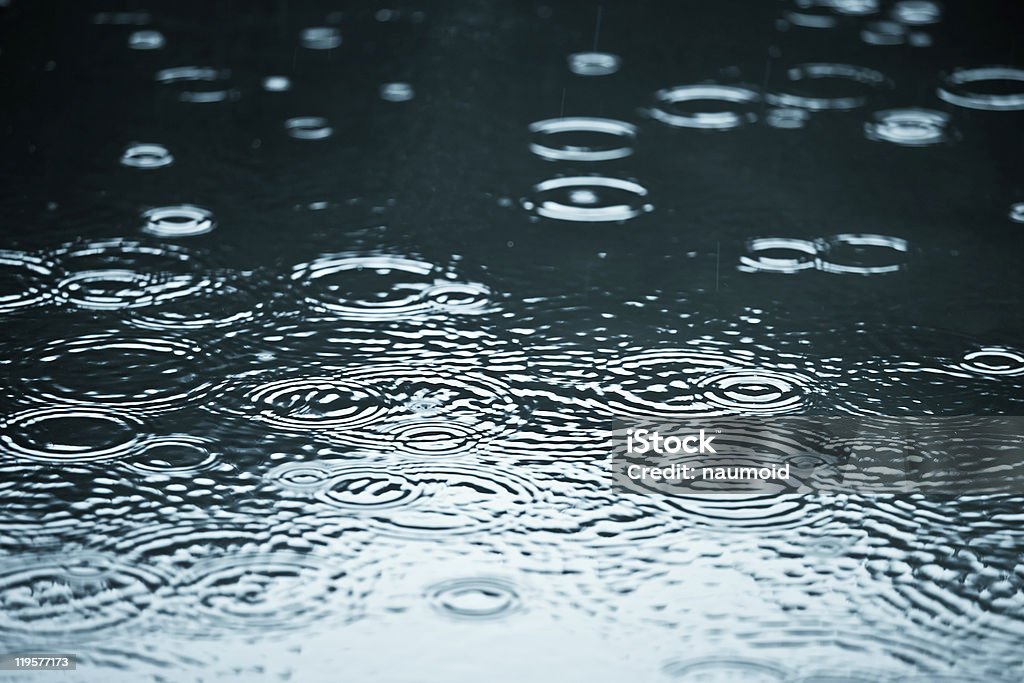 Close-up di una pozzanghera con gocce di pioggia increspature - Foto stock royalty-free di Goccia di pioggia
