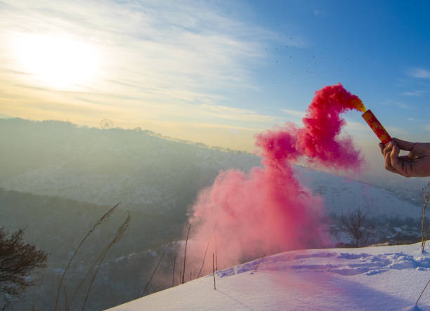 istock smoke bomb in hand with red smoke in winter mountains 1195773700