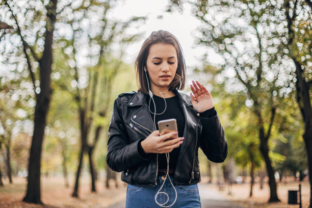 istock Young woman is texting at the park 1195773755