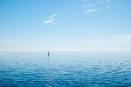 Sweden: single sailing boat with calm sea and blue sea and horizon