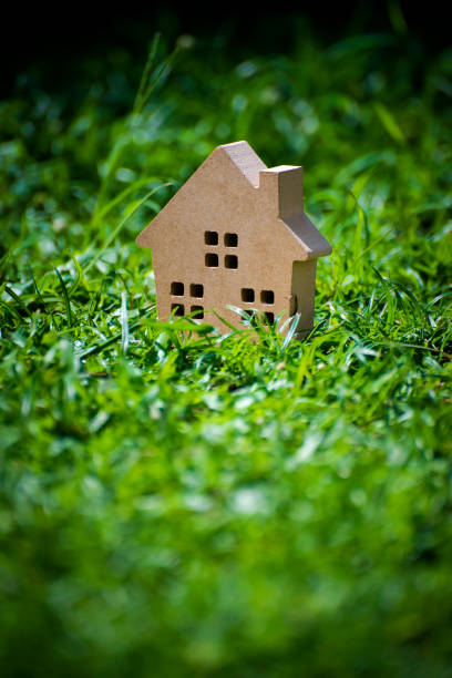 Cutting of a blank sheet, house shaped above a green field background