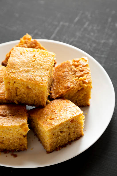 istock Homemade Sliced Cornbread Ready to Eat on a white plate on a black background, low angle view. Copy space. 1195777994