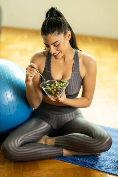 istock Woman eating healthy salad 1195778856