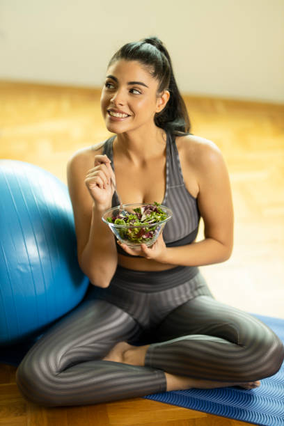 istock Woman eating vegetables salad 1195778906