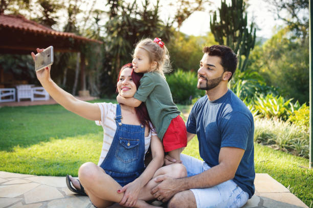 istock Family together taking a selfie outdoors in the backyard 1195779742