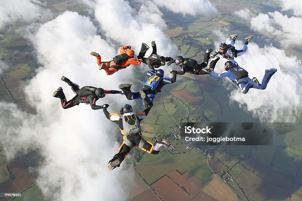 Otto skydivers in caduta libera attraverso le nuvole - Foto stock royalty-free di Skydiving