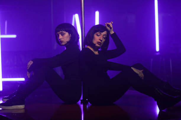 dos mujeres con bob haircut posing en el club nocturno - two people only women pole dancing fotografías e imágenes de stock