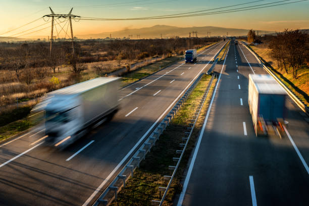 istock Fast blurred delivery trucks in high speed motion driving on a highway 1195805383
