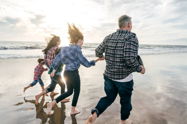 istock Family running on the beach 1195807802