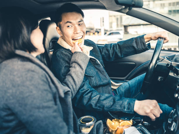 istock Asian couple snacking in the car 1195807818