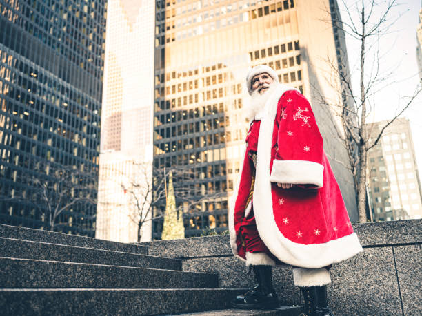 Santa Clause on downtown street in big North American city. Long white beard, Red suit, boots and all. Ready for Christmas.