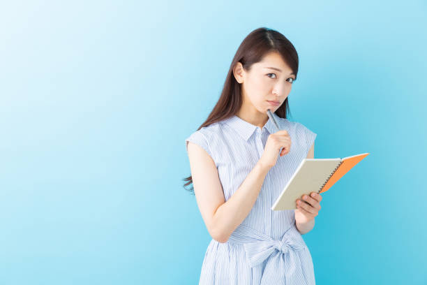 istock asian women is taking notes and think 1195825930