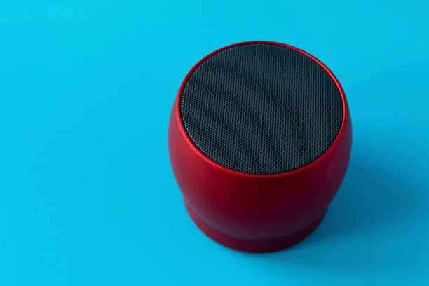 istock Wireless and powerful red speaker on a blue background. Speaker to enhance volume. 1195833177