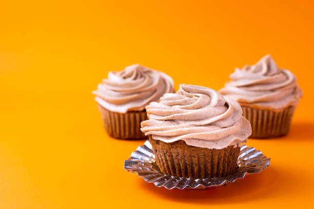 istock Pumpkin cupcakes on orange background 1195833238