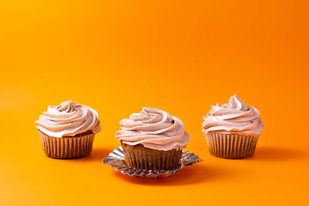 istock Pumpkin cupcakes on orange background 1195833246