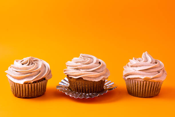 istock Pumpkin cupcakes on orange background 1195833253