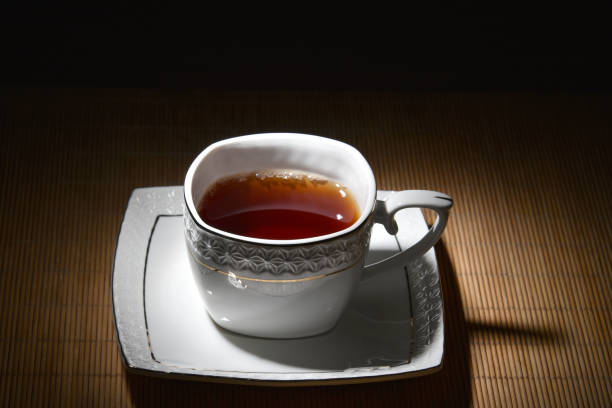 White cup of tea on a white saucer on bamboo napkin