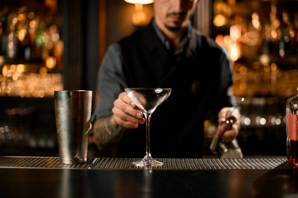 istock Bartender grabbing a cocktail glass for martini 1195836776